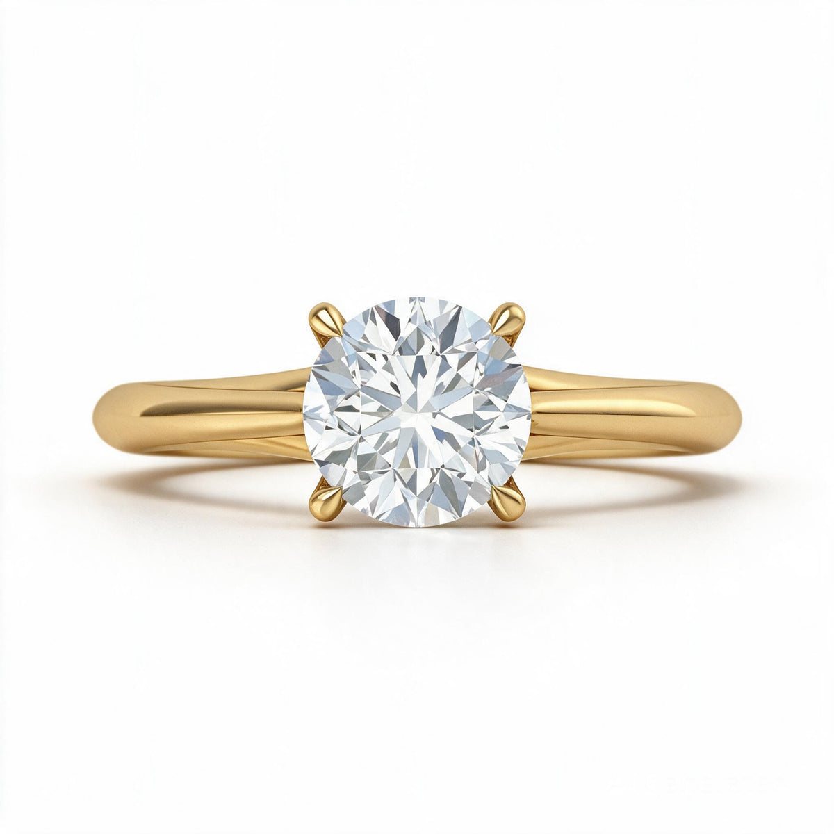 A classic yellow gold solitaire engagement ring featuring a round brilliant-cut diamond center stone in a four-prong setting, shown on a clean white background.