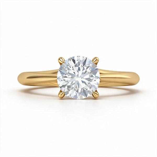 A classic yellow gold solitaire engagement ring featuring a round brilliant-cut diamond center stone in a four-prong setting, shown on a clean white background.