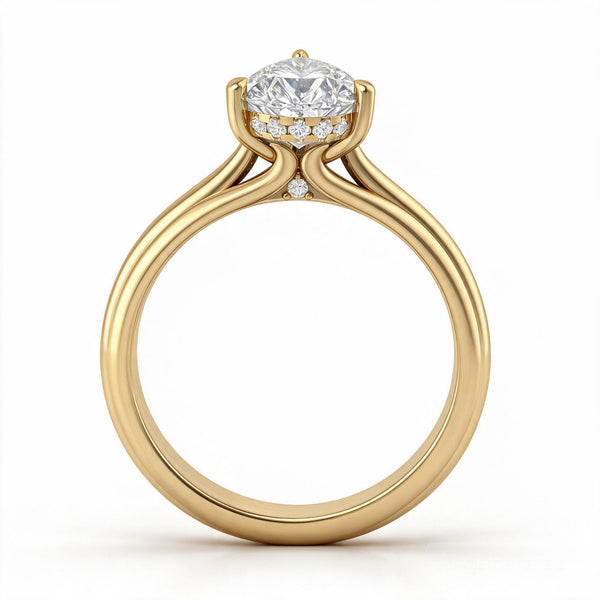 A yellow gold engagement ring featuring a Pear-cut center diamond surrounded by a halo of smaller diamonds, set on a split shank band with Onya's Signature Collet